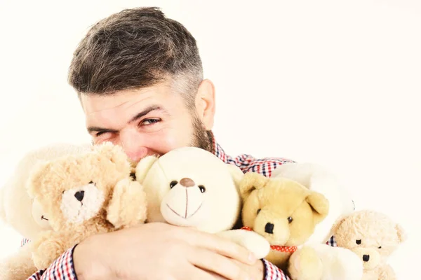 Macho com barba abraça muitos ursos de pelúcia e brinquedos de pelúcia . — Fotografia de Stock