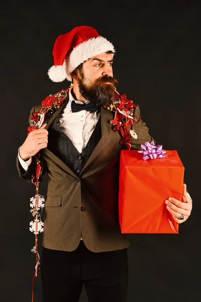 Менеджер с бородой держит красный подарок. Человек в умном костюме — стоковое фото