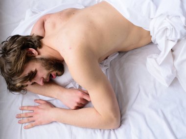 Tıraşsız yakışıklı adam çıplak gövde uyku nap yatak üstten görünüm üzerinde dostum. Adam uykulu tıraşsız sakallı yüzü dinlenme var. Rahat şilte ve yastıklar üzerinde uyku. Şekerleme zamanı. Bırak vücudun rahat hissediyorum