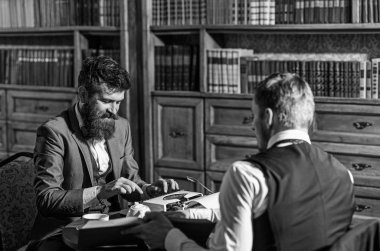 Takım elbiseli bir adam veya kütüphanede arkadaşı olan bir gazeteci..