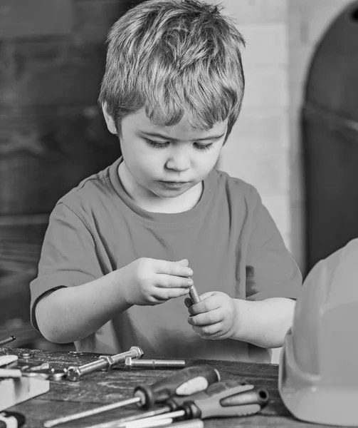 Vértes gyerek játszik a fém csavarok. Kis munkás műhelyben. Aranyos fiú piros póló, a tábla mögött — Stock Fotó