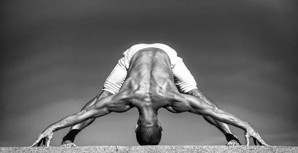 En yoga la clave para mantenerse joven es una columna vertebral flexible. Instructor de yoga con cuerpo muscular hacer deporte. Salud mental y física. Hombre musculoso en posición de yoga. Deporte y salud, blanco y negro — Foto de Stock
