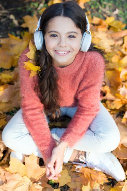 Basit şeylerden zevk alıyorum. Müzik dinle küçük kız. Sonbaharda mutlu küçük kız. Mutlu çocuk giyim kulaklıklar. Sonbahar günü küçük müzik fan. Müzik dışında her şeyi