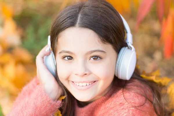 Entregue-se ao sulco. A criança feliz usa auscultadores. Pouco fã de música no dia de outono. Menina feliz no outono. A menina ouve música. Todos merecem música — Fotografia de Stock