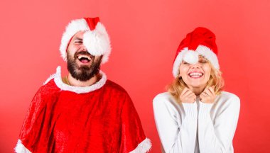 Çift neşeli yüzü Noel kutlaması. Çift kutlamak kış tatil Noel partisi. Sakal ve santa şapka ponpon kırmızı arka plan ile kadında olan adam. Noel maskeli balo veya karnival kavramı