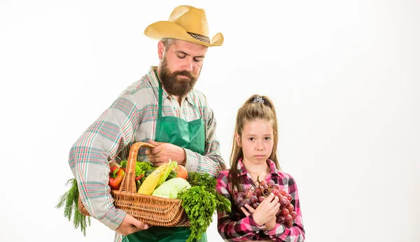 Gardening and harvesting. Family farm organic vegetables. Man bearded rustic farmer with kid. Farmers family homegrown harvest. Father farmer or gardener with daughter hold basket harvest vegetables