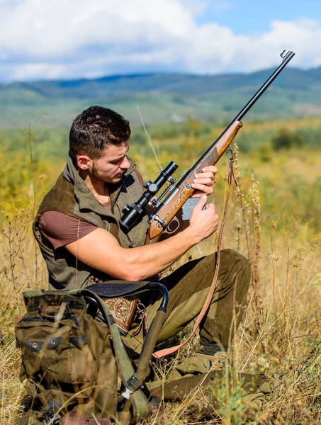 Hunter khaki šaty lovit přírodní pozadí. Lovecké střelby trofej. Hunter s puškou hledá zvíře. Lovecké záliby a volný čas. Muž nabíjecí lovecké pušky. Lovecké vybavení koncept — Stock fotografie