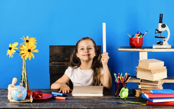 Estudante senta-se em sua mesa com artigos de papelaria coloridos — Fotografia de Stock