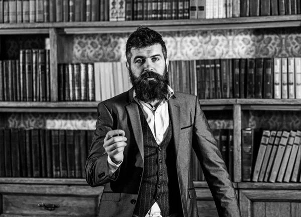 Books and literature. Speaker with calm face stands in vintage interior. Bearded man in elegant suit near bookcase. Mature man with long beard. Discussion, library, argument, style, vintage concept