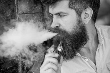 Adam duman e-sigara vurguladı. Yan görünümü vape teneffüs edilmesi adam sakallı. Stres rahatlama ve gevşeme kavramı