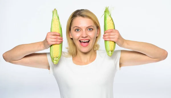 Chica humor juguetón mantenga granos maduros en las manos. Alimento vegetariano y saludable producto orgánico natural. Cocine la receta de maíz. Concepto de nutrición vegetariana. Mujer mantenga mazorca de maíz amarillo sobre fondo blanco —  Fotos de Stock