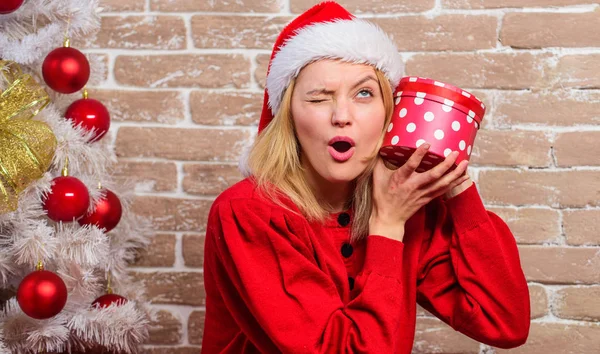 Lady fira jul. Vinter semester koncept. Upphetsad om dagsläget. Klä nära julgran. Uppackning julklapp. Kvinna i santa hatt hålla presentbox. Flicka firar nära julgran — Stockfoto