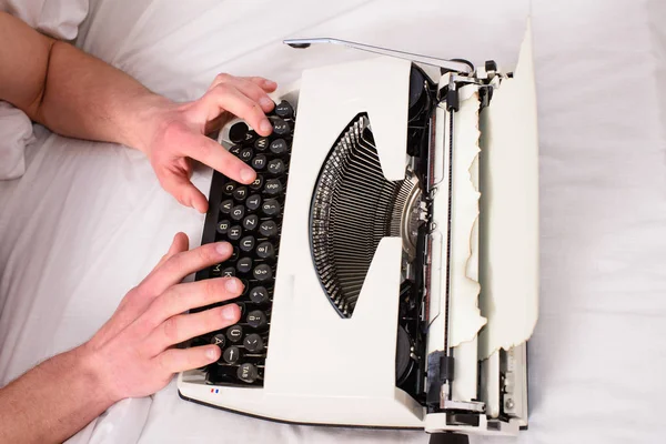 Manos escritor cama ropa de cama blanca trabajando en el nuevo libro. Escritor autor utiliza a la antigua máquina en lugar de gadget digital. Cree una nueva máquina de escribir de uso de capítulo. Concepto de inspiración matinal — Foto de Stock