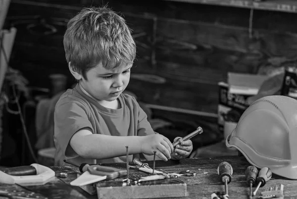 Kisgyermek elfoglalt arcán játszik csavarok otthon a műhelyben. Handcrafting fogalom. Gyerek fiú játszani, mint ezermester. Aranyos és imádnivaló, játszó gyermek csavarok építő vagy javítóműhely, javítás, vagy handcrafting — Stock Fotó