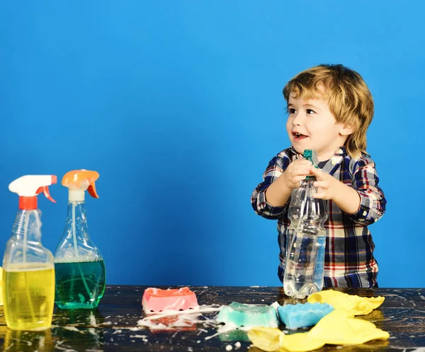 Parents little helper concept. Kid holds spray on table — Stock Photo, Image
