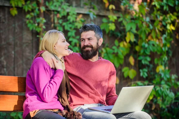 Surfing internet together. Couple with laptop sit bench in park nature background. Family surfing internet for interesting content. Internet surfing concept. Couple in love notebook consume content