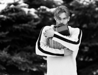 Kışın açık havada hediye kutusu olan yakışıklı bir adam.