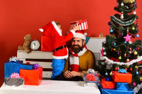 La famiglia di Natale apre regali su sfondo rosso — Foto Stock