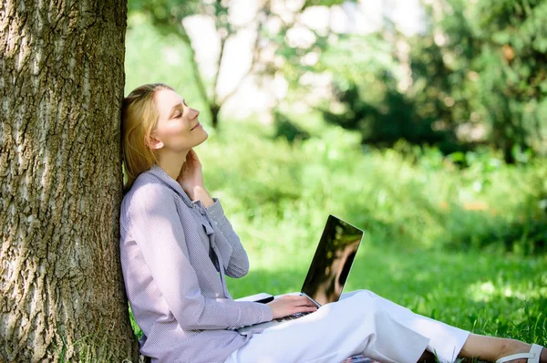 Woman with laptop work outdoors lean tree. Minute for relax. Education technology and internet concept. Girl work with laptop in park sit on grass. Natural environment office. Work outdoors benefits