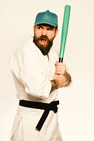 Karate man with greedy face holds green baseball bat. — Stock Photo, Image