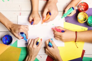 Sanatçılar boyalı ve renkli kağıtlı ahşap masa