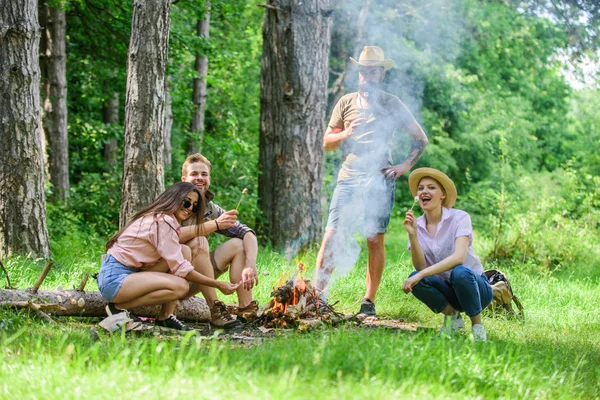 Weekend w lesie korzyści. Prażenie marshmallows popularnej grupy działalności wokół ogniska. Przyjaciele firmy przygotować porcję palone tle natura przekąska. Młodzież na pikniku prażenie marshmallows — Zdjęcie stockowe