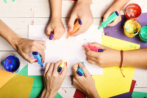 Деревянный стол художников с красками и цветной бумагой