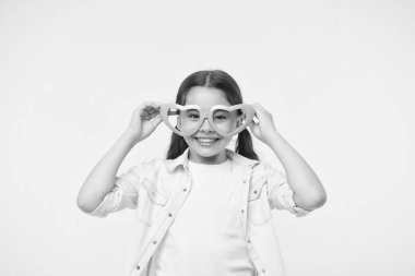 Mutlu çocuk sarı arka planda kalp şeklinde gözlük takıyor. Moda aksesuarlarıyla gülümseyen küçük kız. Yaz modası görünüşü. Funk stili güzellik. Genç ve kendinden emin. Sevgililer Günü. Seni seviyorum.