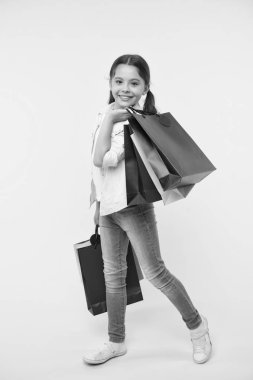 Benim stilini değiştirin. Çocuk şirin fashionista alışveriş. Alışveriş merkezinde alışveriş mutlu bir çocuk. Çocuk kız yüzü gülen taşıyan grup mutlu sarı arka plan paketler. Kız Alışverişkoliğin alışveriş satın giyim seviyor