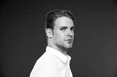 Güven ve erkeklik. Olarak, onun görünümünü kendine güvenen bir adam. Adam iyi bakımlı kıl ve saç modeli koyu arka plan ile. Maço emin katı yüz kapatın. Adam yakışıklı çekici beyaz gömlek