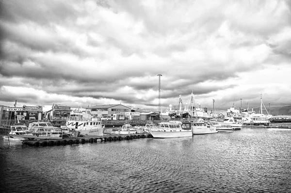 Рейкьявик, Исландия - 13 октября 2017 года: яхты на морском пирсе в маленькой деревне. Парусные лодки на побережье в облачном небе. Водный транспорт и путешествие по морю. Отдых или странствия и путешествия — стоковое фото