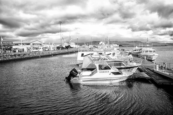 Reykjavik, Islândia - 13 de outubro de 2017: lanchas a motor no cais do mar em pequena aldeia. Iates na costa do mar no céu nublado. Transporte de água e viagens de barco. Férias ou desejo de viajar e viajar — Fotografia de Stock