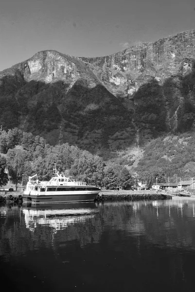 Barco de placer en el muelle del mar en el paisaje de montaña en Flam, Noruega. Pequeño barco en puerto marítimo con montañas verdes. Viajando por agua. Vacaciones de verano y vacaciones. Vagabundo y descubrimiento —  Fotos de Stock
