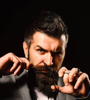 Resmi takım elbiseli maço sakal ve bıyık kesiyor..