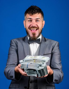 İşadamı nakit para var. Nakit kolay ve hızlı bir şekilde olsun. Nakit işlem iş. Adam mutlu kazanan zengin doları banknot yığını mavi arka plan tutun. Piyango kavramı kazanmak. Kolay nakit krediler