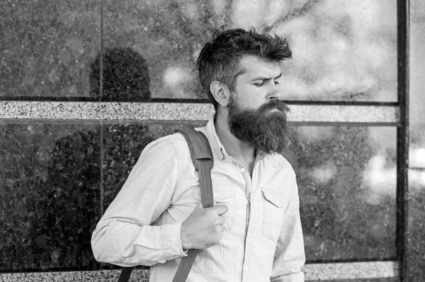 Concepto de estación de autobuses. Hombre con barba larga y elegante que va a viaje de negocios. Hombre con barba en la cara tranquila, fondo de mármol negro. Barbudo hombre lleva bolsa en el hombro mientras espera autobús o taxi —  Fotos de Stock