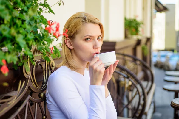 Mug of good coffee in morning gives me energy charge. Girl drink coffee every morning at same place as daily ritual. Have sip of hot aromatic beverage. Woman have drink cafe terrace outdoors