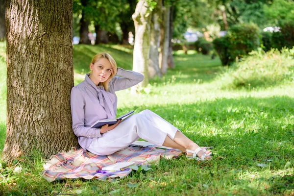 女性自我改善。自我改进书。商务小姐找一分钟看书提高她的知识。女孩靠在树上放松在公园里坐着草。自我完善与教育理念 — 图库照片