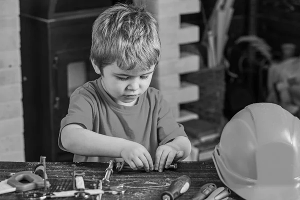 Gyerek rögzítő két fém részleteket. Koncentrált fiú csavaros működő az bolts. Óvodás, segítve a műhelyben — Stock Fotó