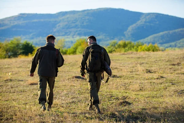 Jägare gevär natur miljö. Hunter vän njuta av fritid. Jakt med partner ger större åtgärd säkerhet ofta roligt och givande. Hunters vänner skogvaktarnas promenad bergen bakgrund — Stockfoto