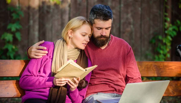 Un paio passano il tempo libero a leggere. Coppia con libro e laptop informazioni di ricerca. Concetto di fonte di informazione. Condividere o scambiare conoscenze informative. L'uomo e la donna utilizzano diversi archivi di informazioni — Foto Stock