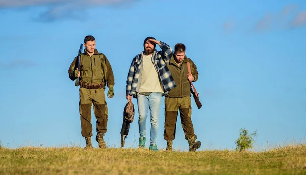 Jacht als hobby en vrije tijd. Jagers met geweren lopen zonnige herfstdag. Brutale hobby. Jongens verzameld voor de jacht. Groep mannen jagers of gamekeepers aard achtergrond blauwe hemel. Mannen dragen jachtgeweren — Stockfoto