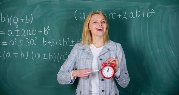 Le importa la disciplina. Es hora de estudiar. Bienvenido año escolar maestro. Buscar profesores comprometidos complementan a los educadores cualificados. Concepto de disciplina escolar. Mujer profesora mantenga el despertador — Foto de Stock