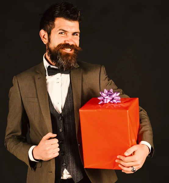 Hombre de negocios con cara sonriente feliz y caja de regalo roja — Foto de Stock