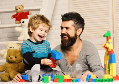 Çocuk ve adam birlikte oynuyorlar. Baba ve çocuklu oyuncaklar