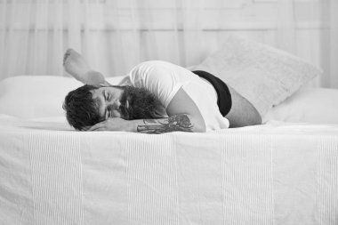 Sakin yüz beyaz çarşaf yatağa kenarında uyuyan adam. Adam arka plan üzerinde beyaz perde yatak, döşeme. NAP ve siesta kavramı. Maço sakal ve bıyık uyku, rahatlatıcı, nap, sahip rest