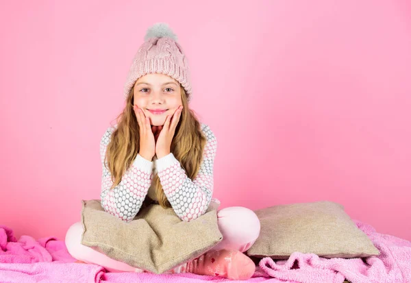 Kid girl use chapéu de malha bonito e roupas confortáveis e aconchegantes. Conceito de moda de inverno. Menina cabelo longo relaxante fundo rosa. Moda de inverno de crianças. Criança modelo de moda sorridente — Fotografia de Stock