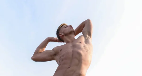 男子肌肉胸部赤裸躯干站立天空背景。强壮的肌肉强调男性性行为。健美身材。性感躯干迷人的身体。男子肌肉健美运动员显示肌肉 — 图库照片