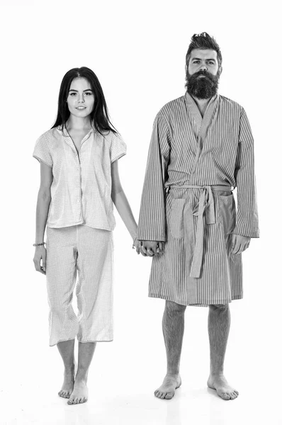 Couple tenir la main ensemble, isolé sur fond blanc. Couple amoureux en pyjama, peignoir. Couple, famille sur les visages souriants dans les vêtements pour dormir semble somnolent le matin. Réveil et concept matinal — Photo