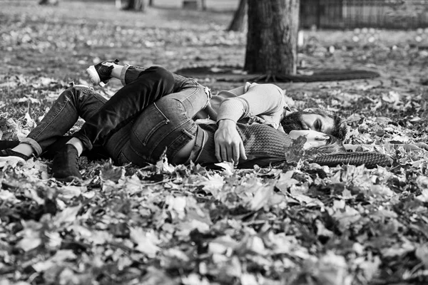 Verliefde paar ligt op de gevallen bladeren in park — Stockfoto